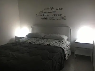 a bedroom with a bed and a sign on the wall at La Casetta di Andrea & Vale in Termini Imerese