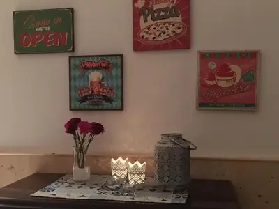 a table with a candle and some pictures on the wall at La Casetta di Andrea & Vale in Termini Imerese