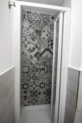 a glass shower door with a patterned wall at Vivere la Ciambra in Monreale