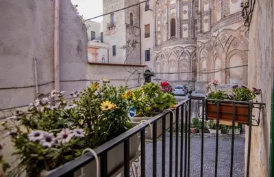 a balcony with a bunch of flowers on a building at Vivere la Ciambra in Monreale
