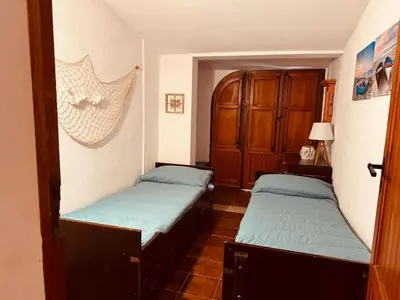 a room with two beds and a cabinet at La maison sul mare in San Vito lo Capo