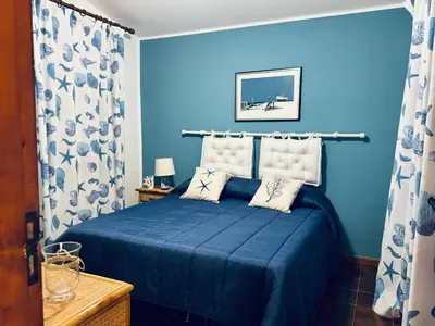 a blue bedroom with a bed with two pillows at La maison sul mare in San Vito lo Capo