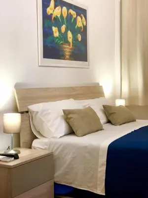 a bedroom with a bed with a painting on the wall at Casa Ina Palermo in Palermo