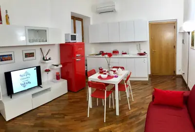 a living room with a table and a red refrigerator at Casa Ina Palermo in Palermo