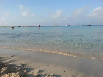 a group of people standing in the water at the beach at Il Mulino in San Vito lo Capo