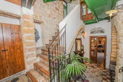 a staircase in a home with stone walls and a wooden door at Locanda Sette Fate SPA e Solarium in Palermo