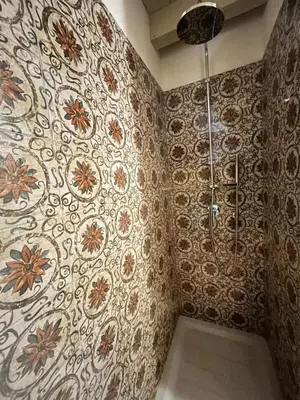 a shower in a bathroom with a floral patterned wall at Locanda Sette Fate SPA e Solarium in Palermo