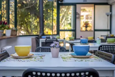 a table with plates and bowls on it in a restaurant at Bouganville Home Mondello in Mondello