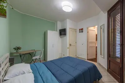 a bedroom with a blue bed and a table at Bouganville Home Mondello in Mondello