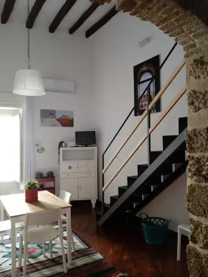 a living room with a staircase and a table at Casa Tea: nel cuore del centro storico in Palermo