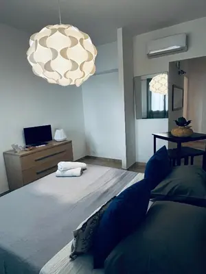 a bedroom with a large bed and a chandelier at Sicilia Vacation in San Vito lo Capo