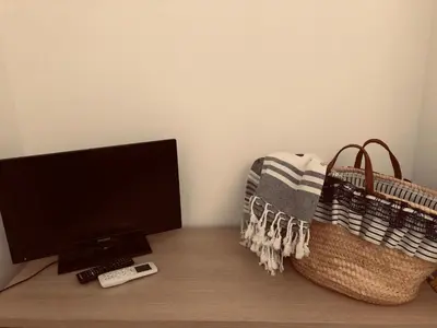 a desk with a television and a wii remote and a basket at Sicilia Vacation in San Vito lo Capo