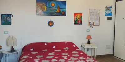 a bedroom with a bed with a red comforter at La Rosa dei Venti in Isola delle Femmine