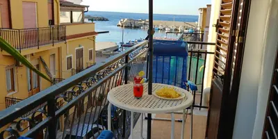 a table with a plate of food on a balcony at La Rosa dei Venti in Isola delle Femmine