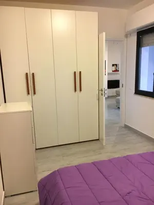 a bedroom with white cabinets and a purple bed at ArtHouse in San Vito lo Capo