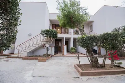 a house with a staircase and trees in front of it at ArtHouse in San Vito lo Capo
