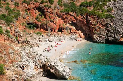 a group of people on a beach in the water at Villa Cycas Costamante in Castellammare del Golfo