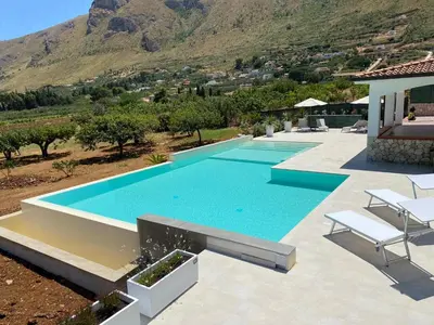 an image of a swimming pool with mountains in the background at Villa Cycas Costamante in Castellammare del Golfo