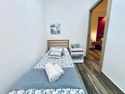 two beds in a small room with a mirror at Casa di Ivana in Carini