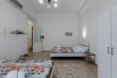 two beds in a room with white walls at GuestHost - Palermo Central Apartment in Palermo
