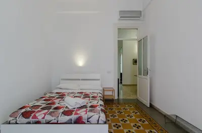 a bedroom with a bed with a quilt on it at GuestHost - Palermo Central Apartment in Palermo