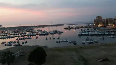 a marina with boats in the water at dusk at Villa Plaia in Castellammare del Golfo