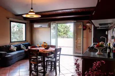 a kitchen and living room with a table and chairs at Villa Plaia in Castellammare del Golfo