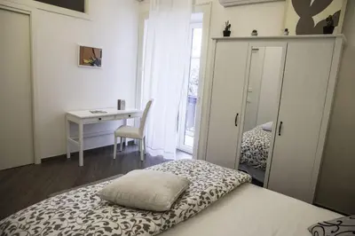 a bedroom with a bed and a desk and a window at Kalatfimi b&b in Palermo