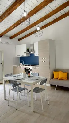 a dining room with a table and chairs in a kitchen at Ficodì apartments in Alcamo