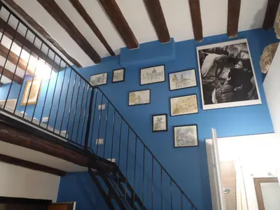 a blue wall with framed photos on a staircase at Casetta di Pietre Chico in Palermo