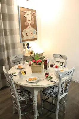 a table with two chairs and a table with food on it at Casetta di Pietre Chico in Palermo