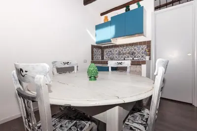 a dining room with a white table and chairs at Casetta di Pietre Chico in Palermo