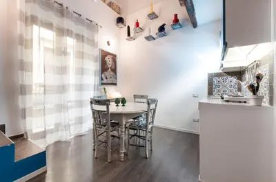 a kitchen with a table and chairs in a room at Casetta di Pietre Chico in Palermo