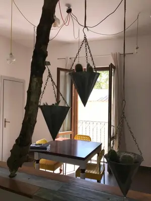 a dining room with a table and a tree at Casetta dei Legni in Palermo