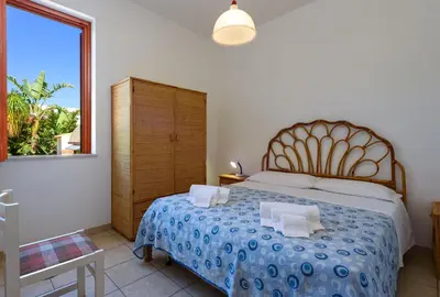a bedroom with a bed with two pillows and a window at Casa Vacanza Azzurra 3 in San Vito lo Capo