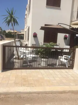 a fence with chairs and tables and an umbrella at Casa Rosita in San Vito lo Capo