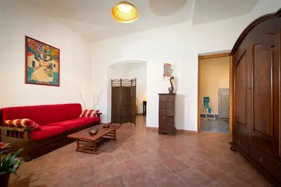 a living room with a red couch and a table at Il Sole di Sicilia in Castellammare del Golfo