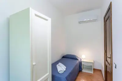 a small bedroom with a blue bed and a door at Appartamenti Karma vacanze in Castelluzzo