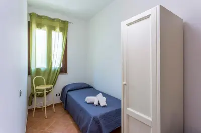 a small bedroom with a bed with a stuffed animal on it at Appartamenti Karma vacanze in Castelluzzo