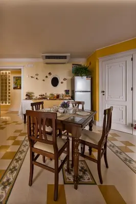 a kitchen with a table and chairs and a refrigerator at Casa Manzella in Terrasini