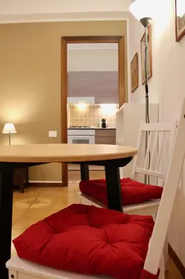 a dining room table with a red pillow under it at Gli Artisti Apartments & Rooms in Bagheria