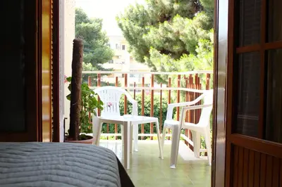a bedroom with a bed and two chairs on a balcony at Gli Artisti Apartments & Rooms in Bagheria