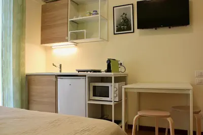 a room with a bed and a kitchen with a microwave at Gli Artisti Apartments & Rooms in Bagheria