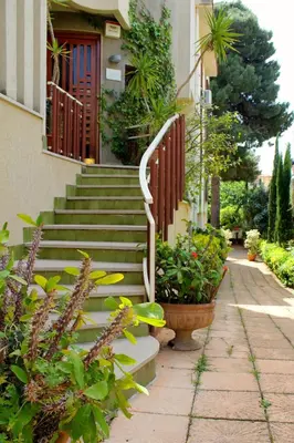 a house with stairs and plants in front of it at Gli Artisti Apartments & Rooms in Bagheria