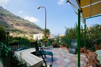 a patio with two chairs and a table and a bench at Marina in Castellammare del Golfo