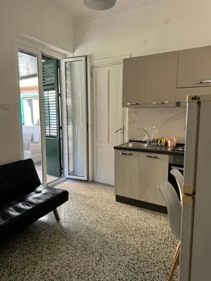 a kitchen with a black couch in a room at Holiday mondello martina in Mondello