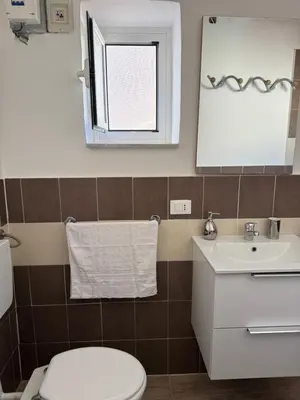 a bathroom with a toilet and a sink and a mirror at Holiday mondello martina in Mondello