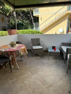 a patio with a table and chairs and a staircase at Holiday mondello martina in Mondello