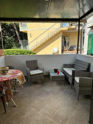 a patio with chairs and a table and a staircase at Holiday mondello martina in Mondello