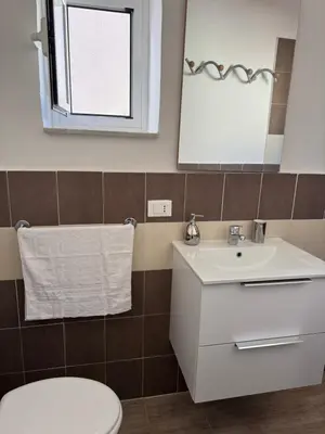 a bathroom with a toilet and a sink and a mirror at Holiday mondello martina in Mondello